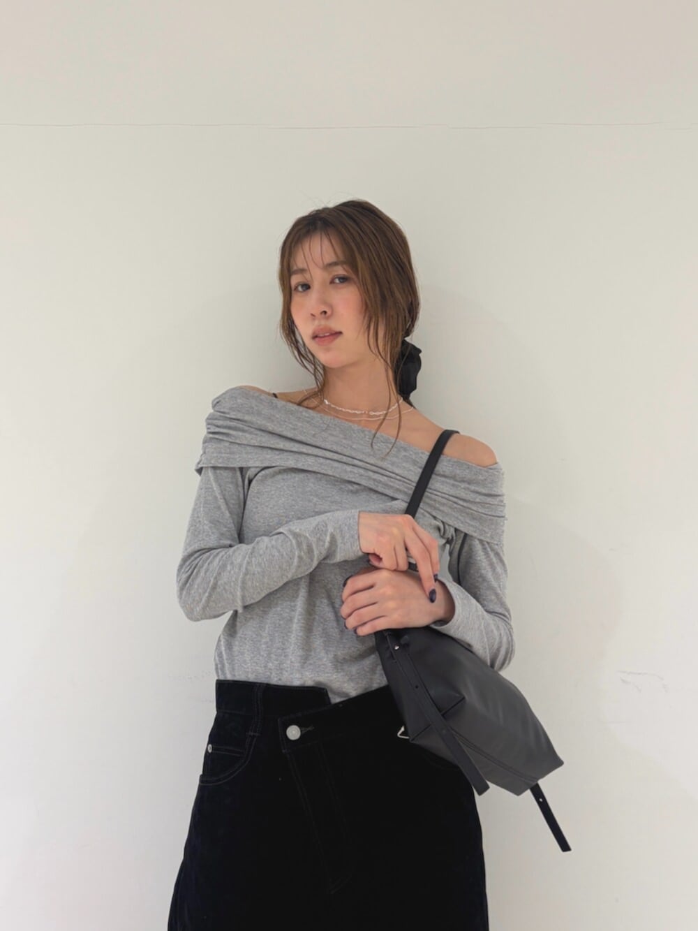 グレー系のTシャツ/カットソー、ブラック系のデニムパンツ、ブラック系のハンドバッグを着用したレディースの秋コーディネートの4枚目の写真