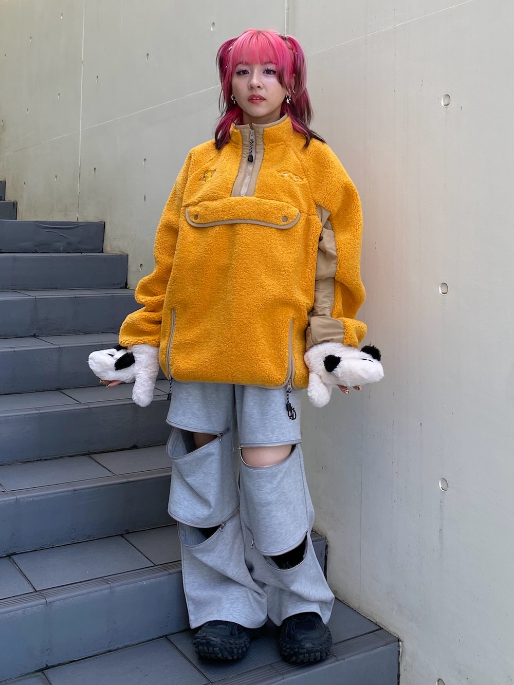 オレンジ系のその他トップス、グレー系のその他パンツ、ホワイト系の手袋を着用したレディースの秋コーディネートの2枚目の写真