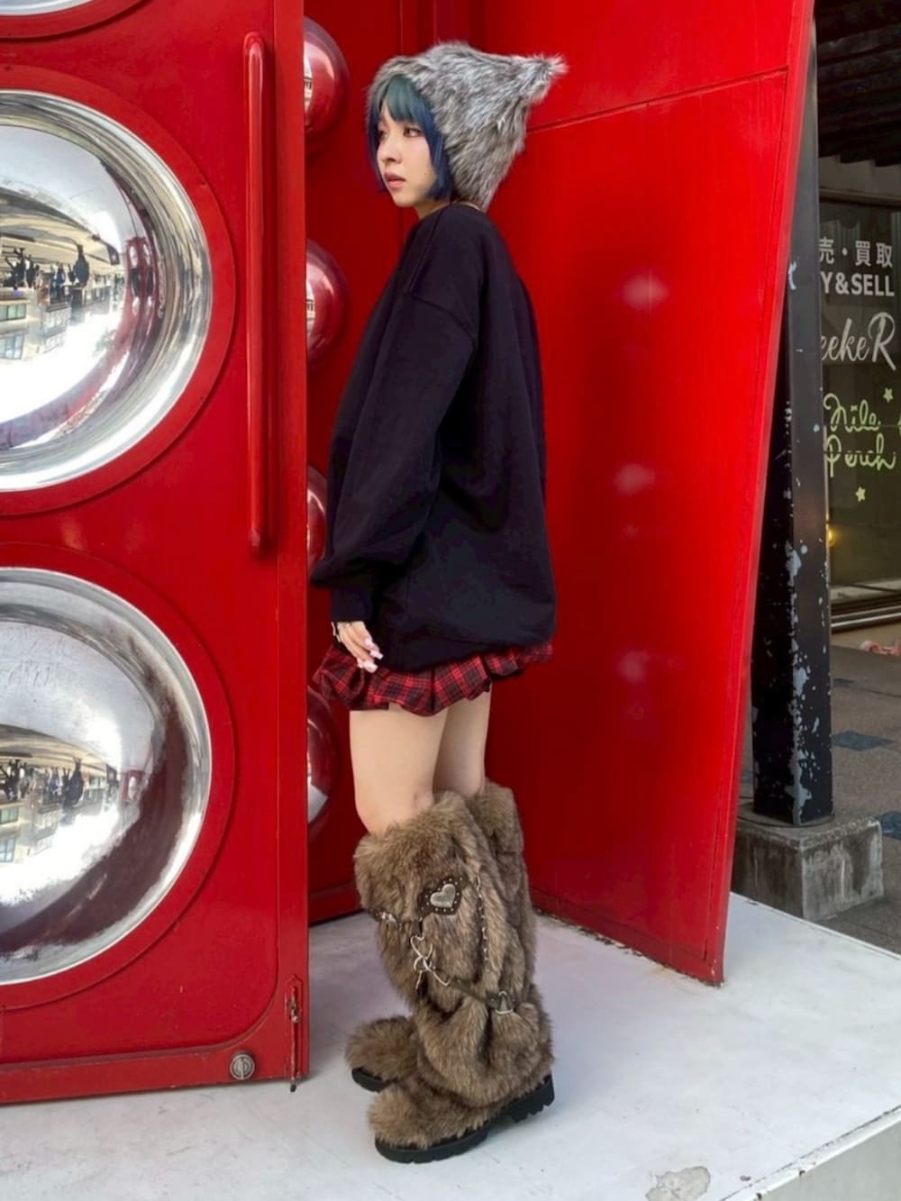 ブラウン系のブーツ、ブラック系のスウェット、レッド系のスカートを着用したレディースの冬コーディネートの3枚目の写真