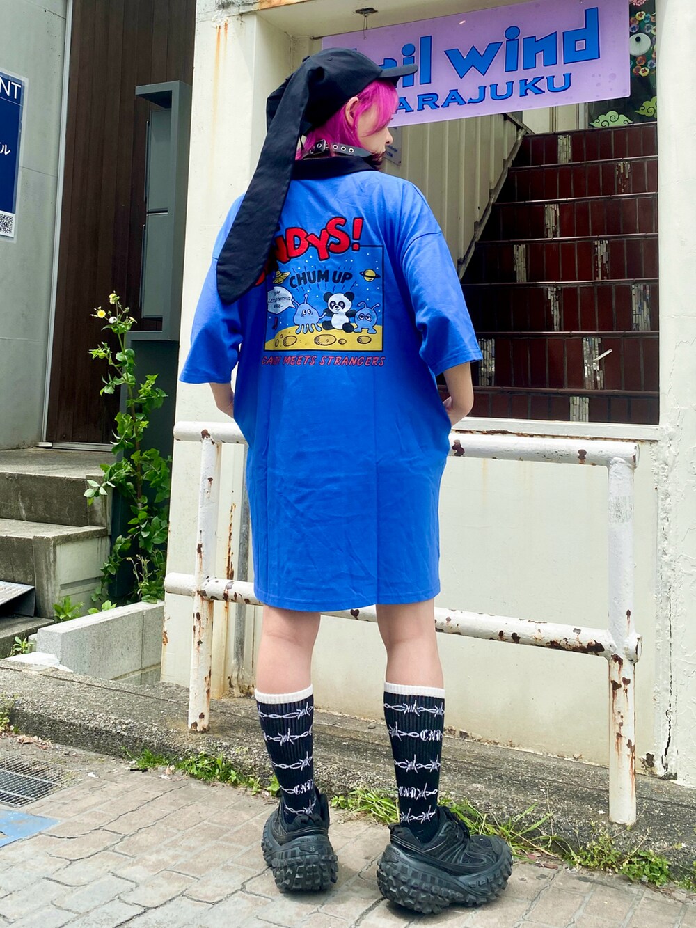 ブルー系のワンピース、ブラック系のボストンバッグ、ブラック系のキャップを着用したレディースの春コーディネートの4枚目の写真