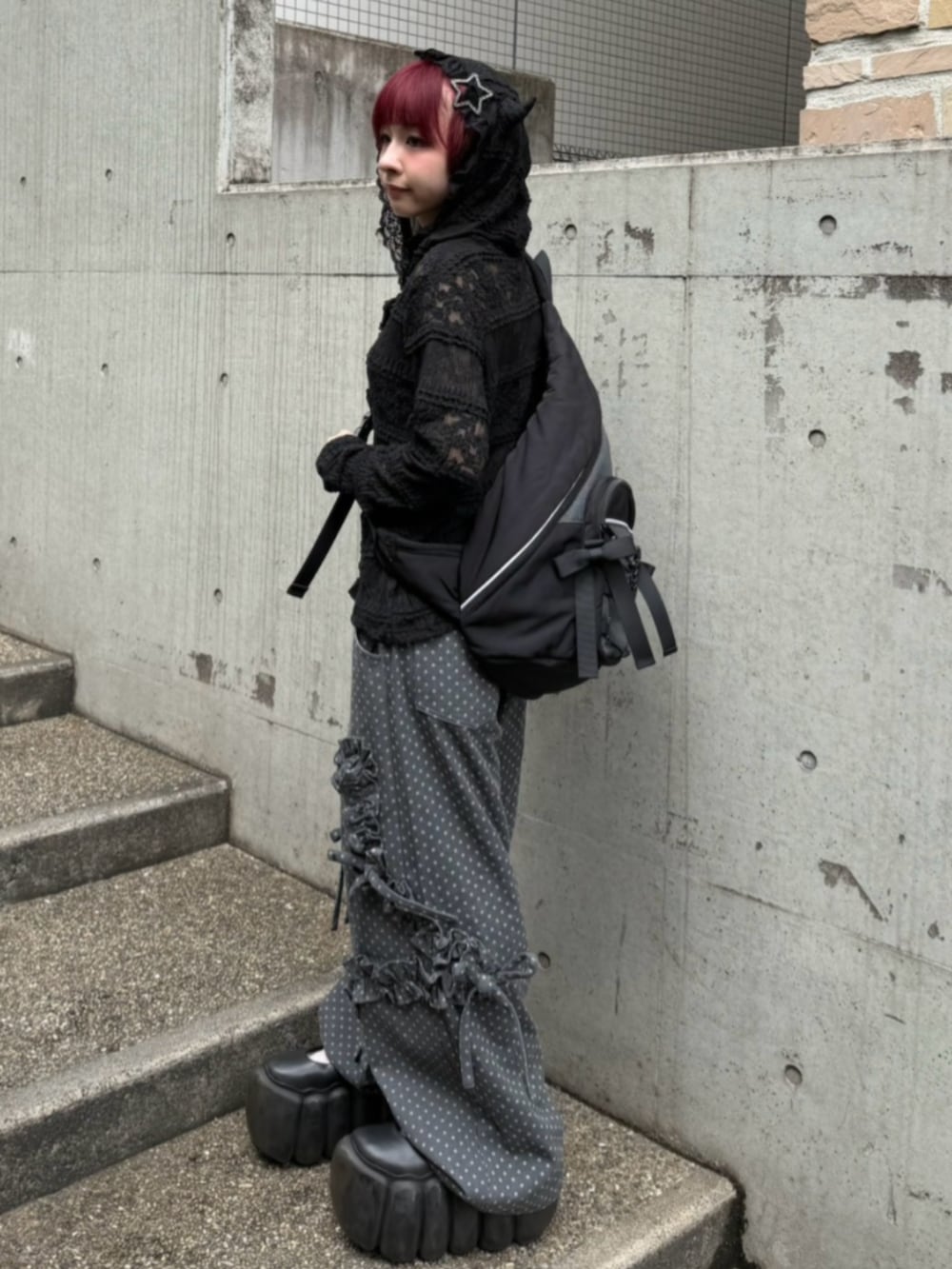 ブラック系のパーカー、ブラック系のショルダーバッグ、ブラック系のデニムパンツを着用したレディースの秋コーディネートの2枚目の写真