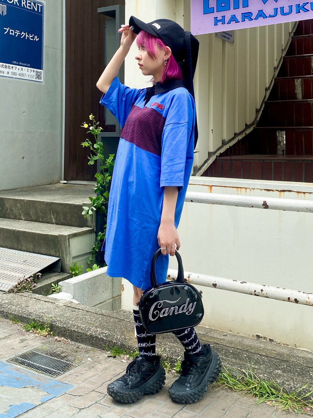 ブルー系のワンピース、ブラック系のボストンバッグ、ブラック系のキャップを着用したレディースの春コーディネートの3枚目の写真