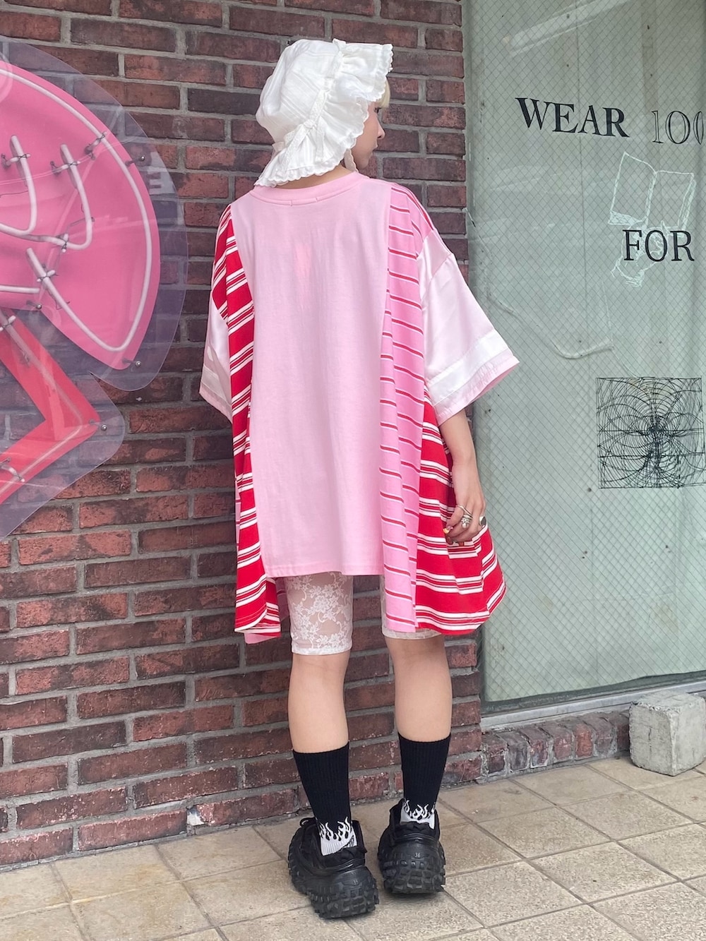 ピンク系のTシャツ/カットソー、レッド系のその他パンツ、ホワイト系のハットを着用したレディースの夏コーディネートの5枚目の写真