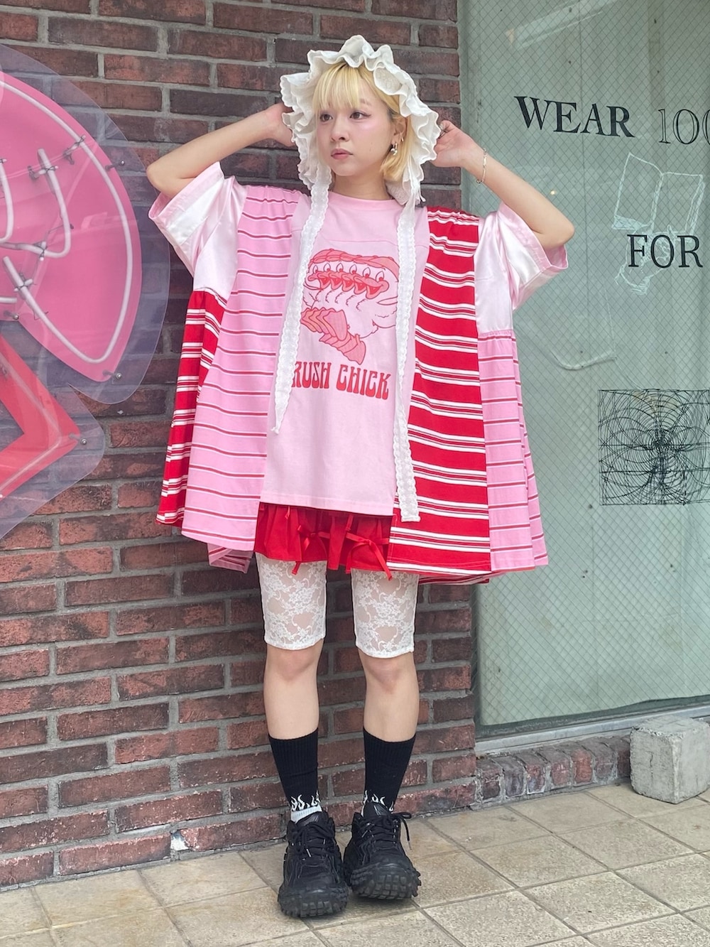 ピンク系のTシャツ/カットソー、レッド系のその他パンツ、ホワイト系のハットを着用したレディースの夏コーディネートの3枚目の写真