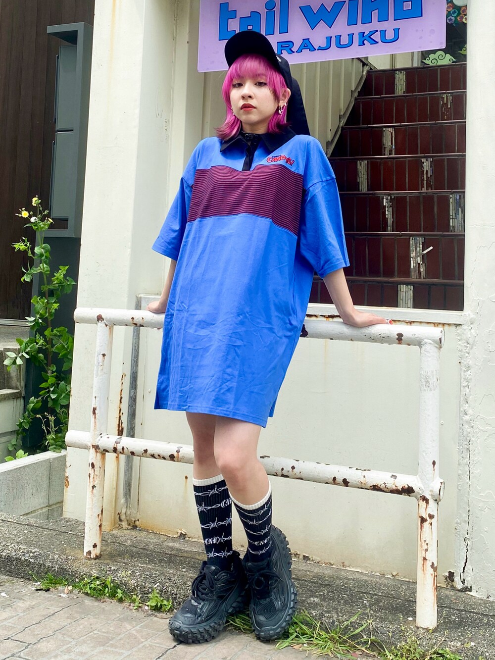 ブルー系のワンピース、ブラック系のボストンバッグ、ブラック系のキャップを着用したレディースの春コーディネートの2枚目の写真