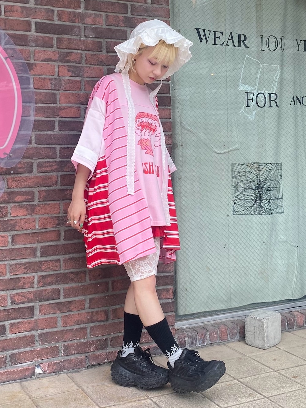 ピンク系のTシャツ/カットソー、レッド系のその他パンツ、ホワイト系のハットを着用したレディースの夏コーディネートの4枚目の写真