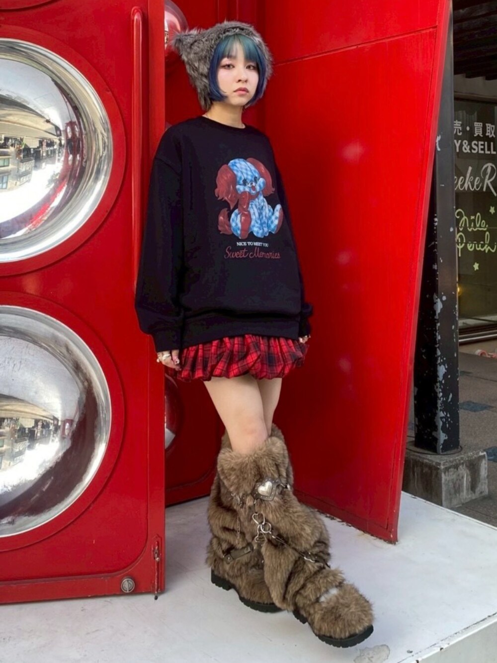 ブラウン系のブーツ、ブラック系のスウェット、レッド系のスカートを着用したレディースの冬コーディネートの2枚目の写真