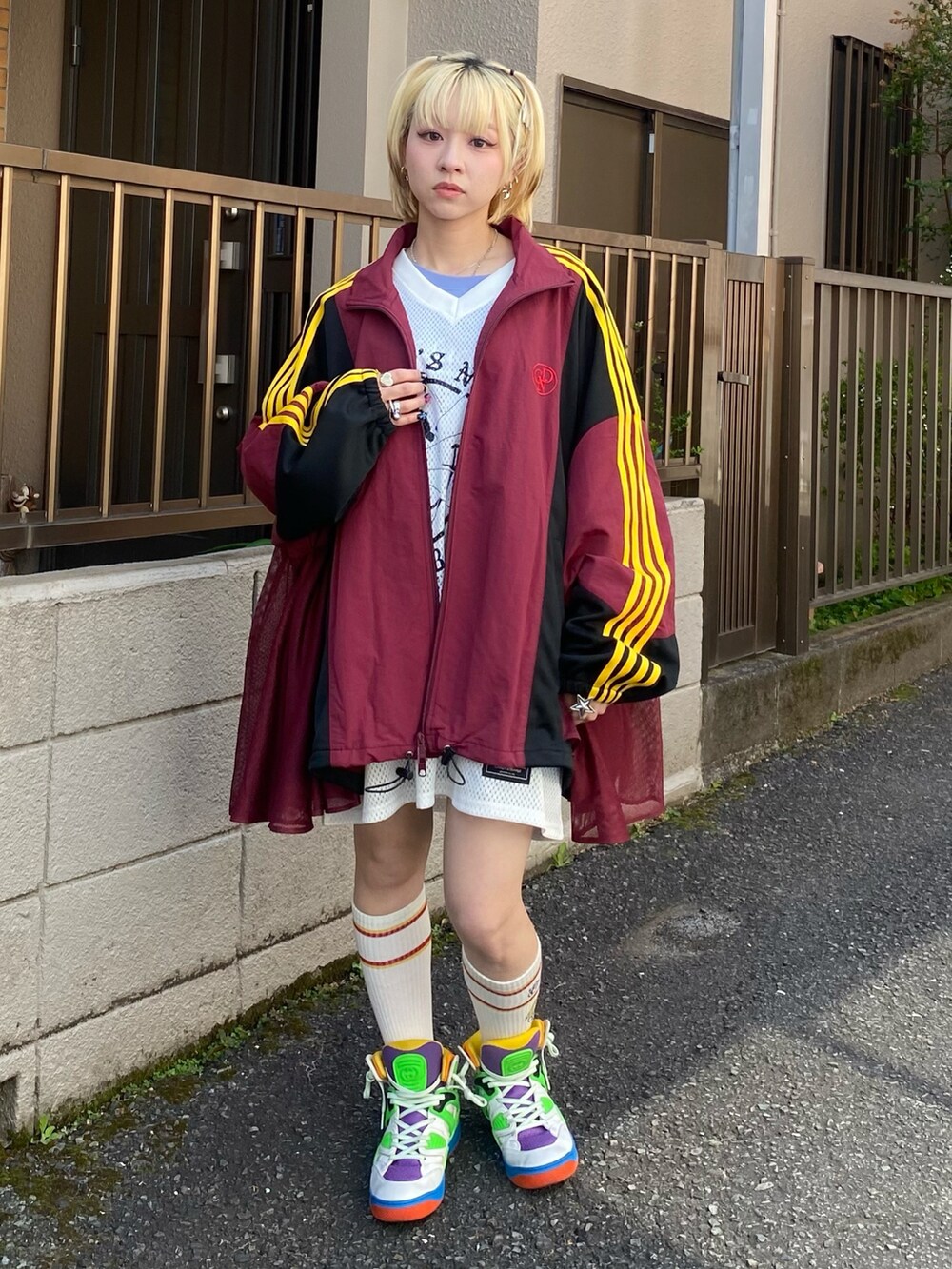 レッド系のブルゾン、ホワイト系のTシャツ/カットソー、ブルー系のTシャツ/カットソーを着用したレディースの春コーディネートの2枚目の写真