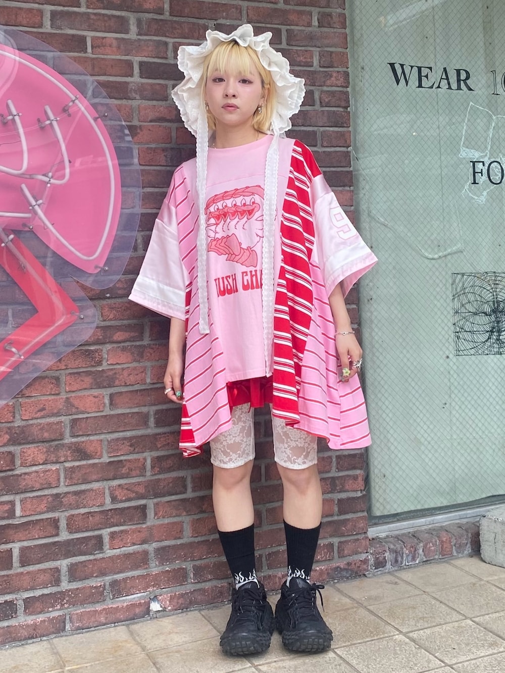 ピンク系のTシャツ/カットソー、レッド系のその他パンツ、ホワイト系のハットを着用したレディースの夏コーディネートの2枚目の写真