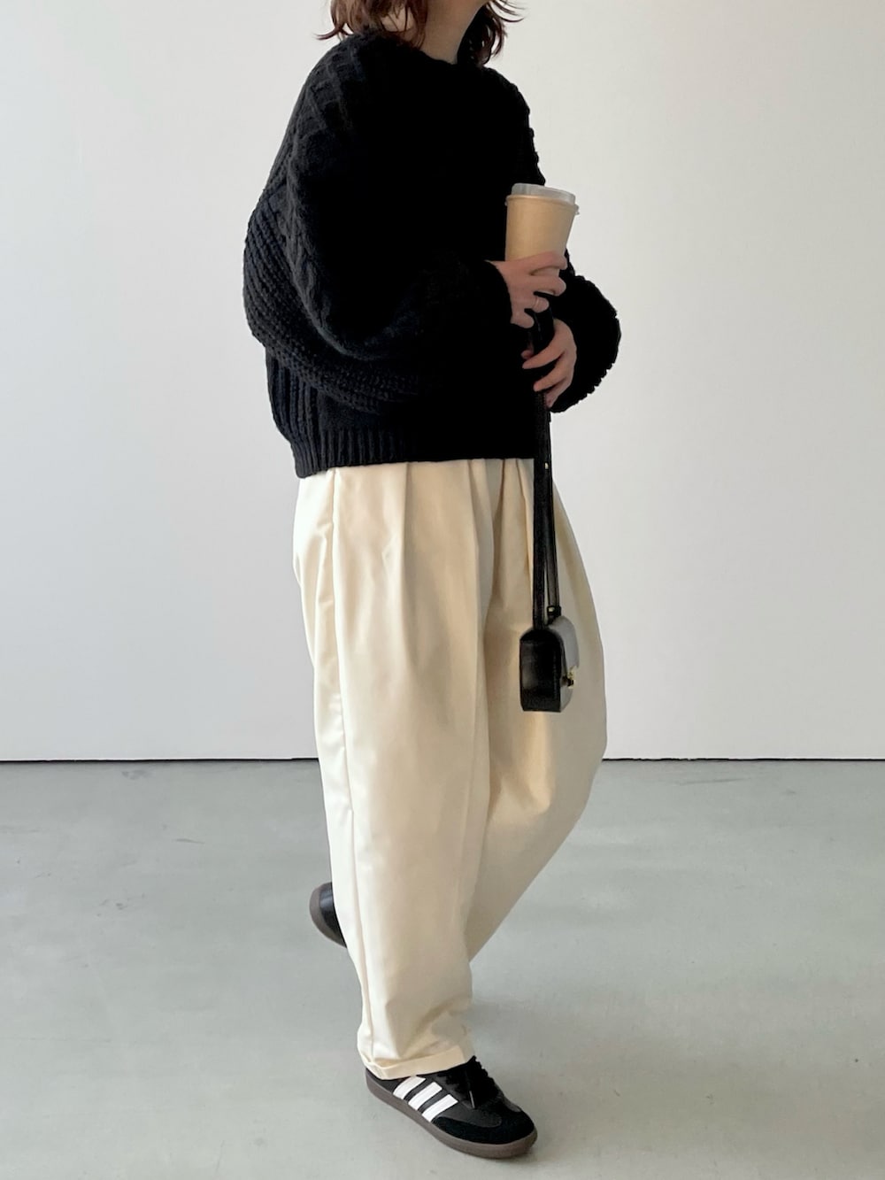 ブラック系のニット/セーター、ホワイト系のその他パンツ、ブラック系のスニーカーを着用したレディースの冬コーディネートの3枚目の写真