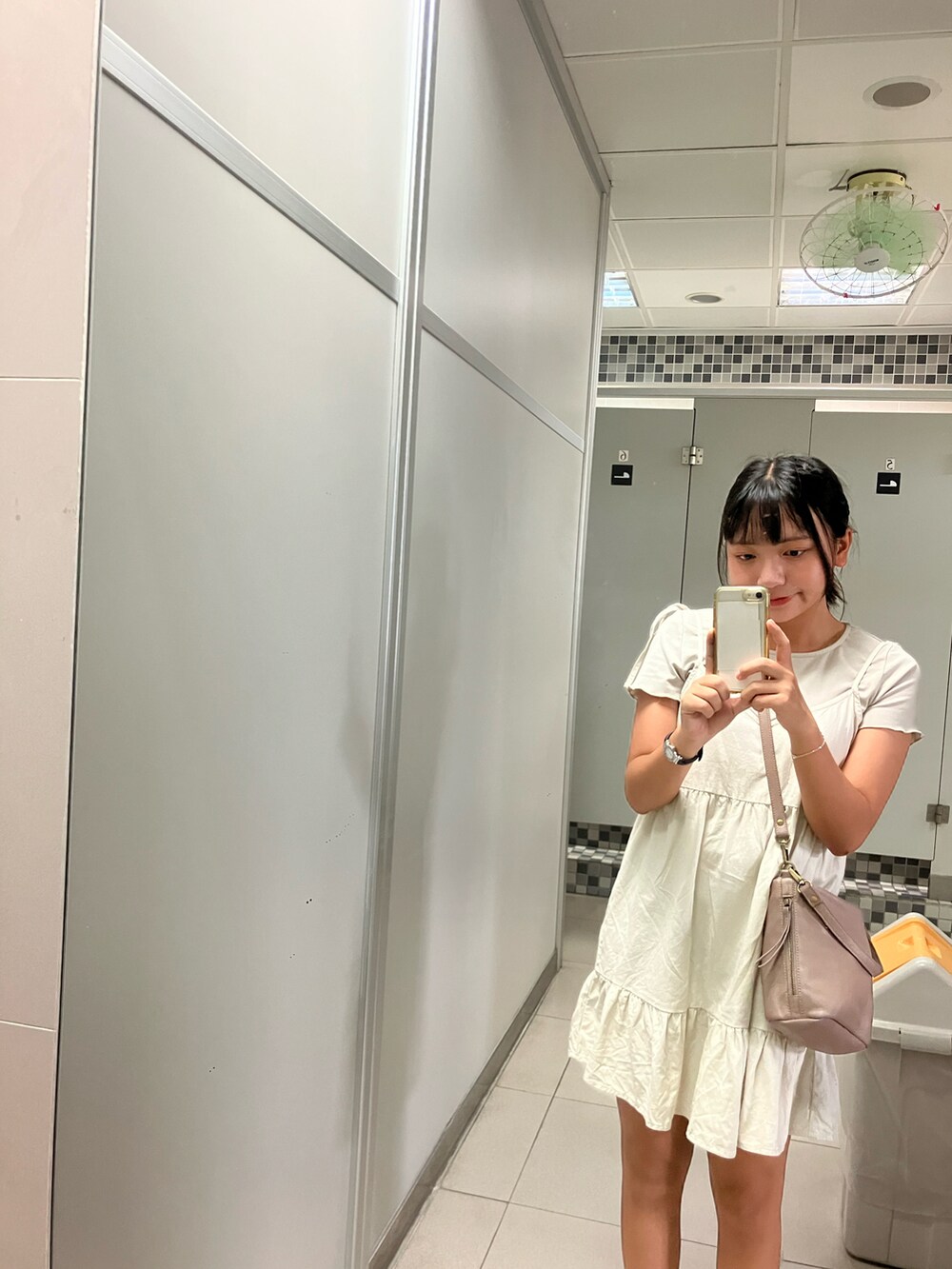 ベージュ系のシャツワンピース、ブラウン系のショルダーバッグを着用したレディースの夏コーディネートの3枚目の写真