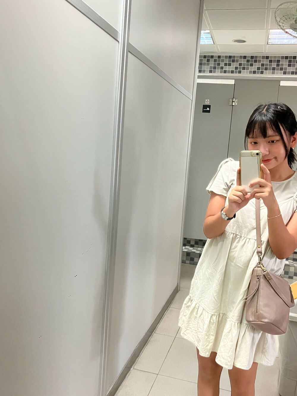 ベージュ系のシャツワンピース、ブラウン系のショルダーバッグを着用したレディースの夏コーディネートの2枚目の写真