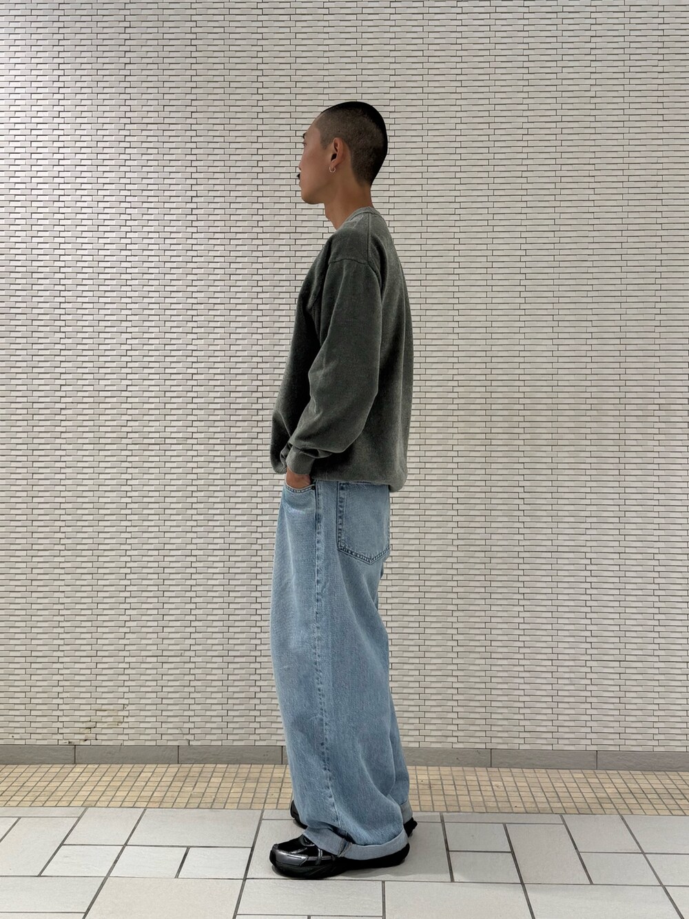 グリーン系のニット/セーターを着用したメンズの秋コーディネートの2枚目の写真