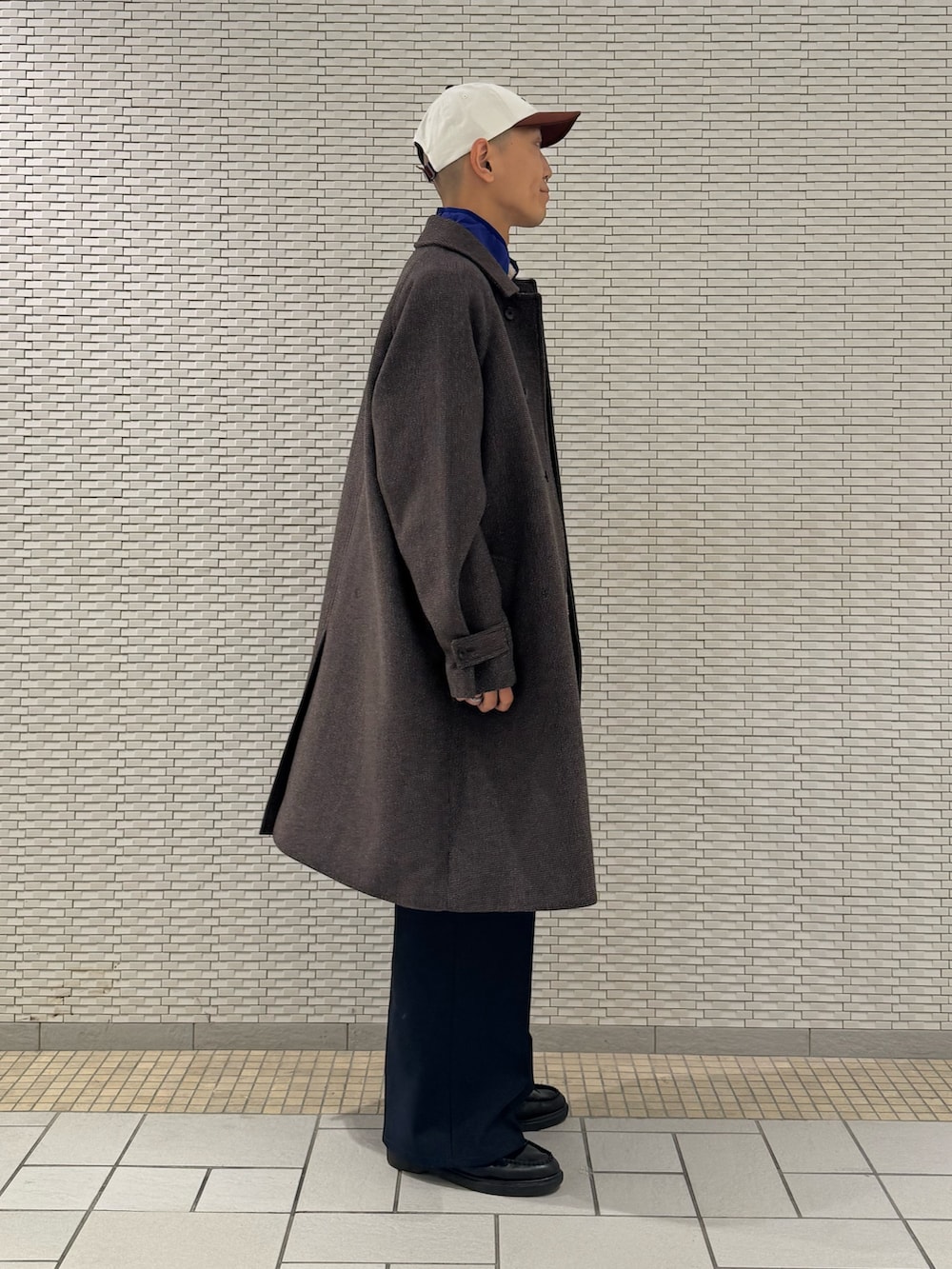 その他のステンカラーコート、ベージュ系のベストを着用したメンズの秋コーディネートの2枚目の写真