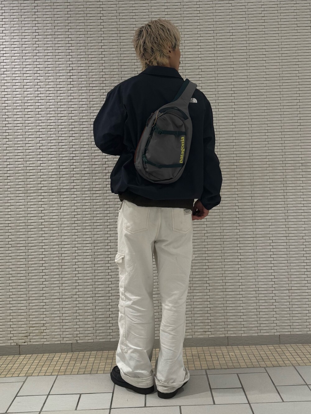 ブルー系のナイロンジャケット、ブラウン系のカーディガン/ボレロを着用したメンズの秋コーディネートの3枚目の写真