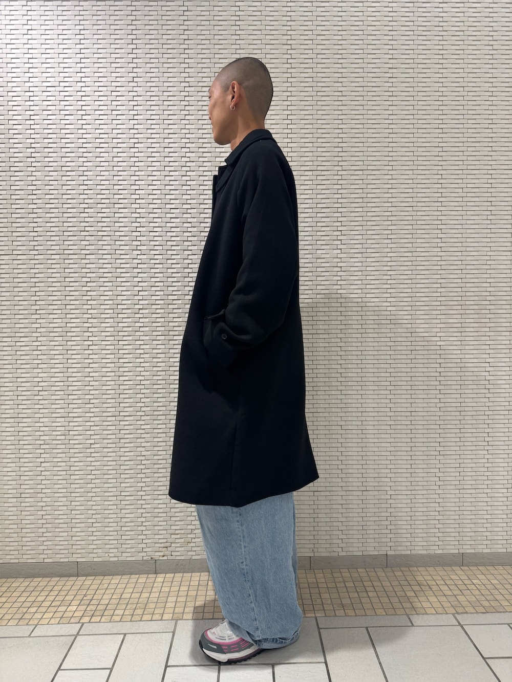 ブラック系のステンカラーコートを着用したメンズの冬コーディネートの2枚目の写真