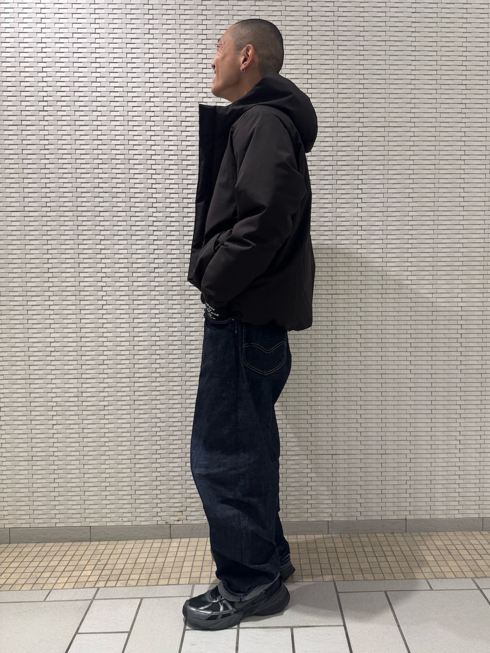 ブラック系のダウンジャケット/コート、ブラック系の手袋を着用したメンズの冬コーディネートの2枚目の写真