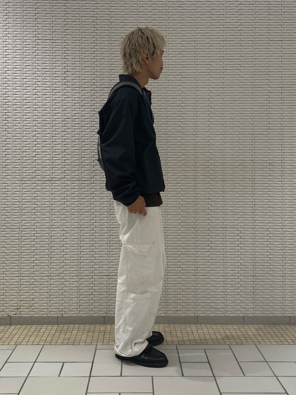 ブルー系のナイロンジャケット、ブラウン系のカーディガン/ボレロを着用したメンズの秋コーディネートの2枚目の写真