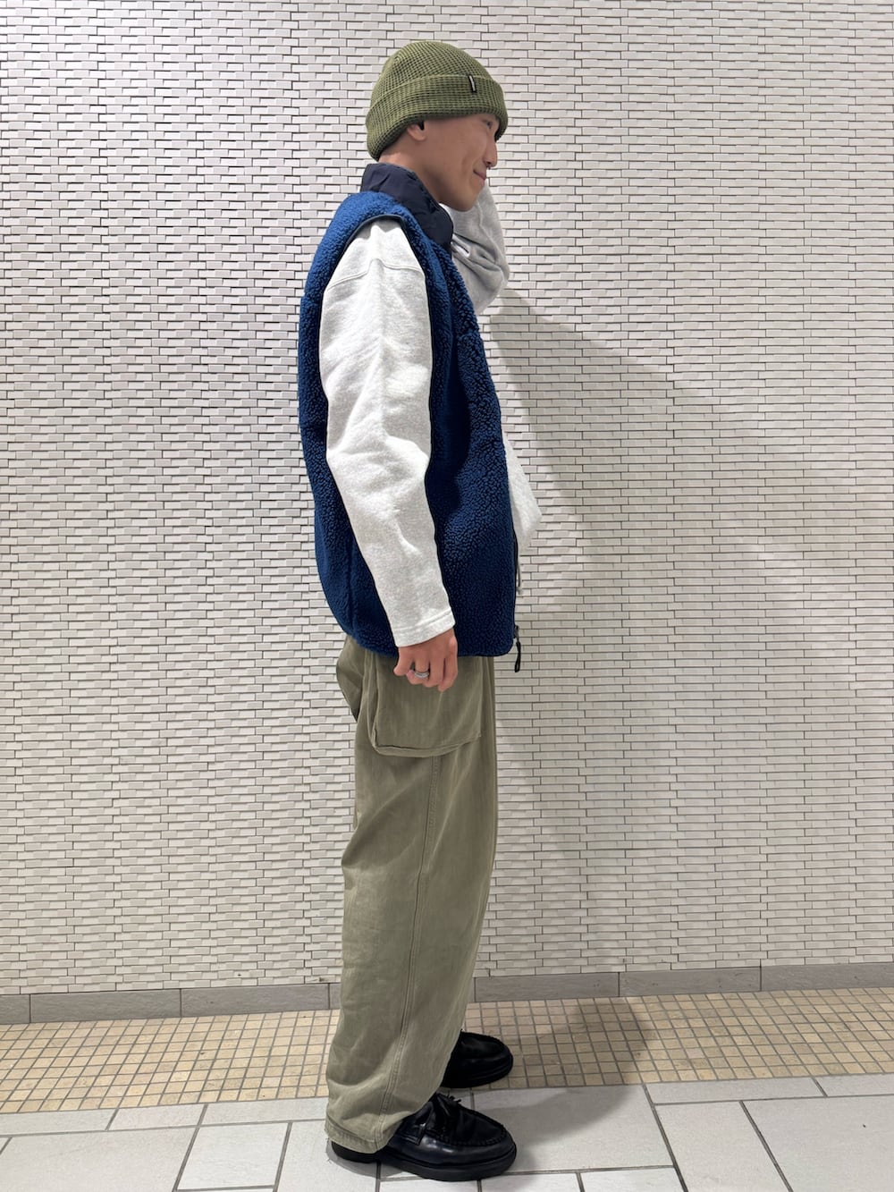 ブルー系のベスト、グレー系のスウェットを着用したメンズの秋コーディネートの2枚目の写真