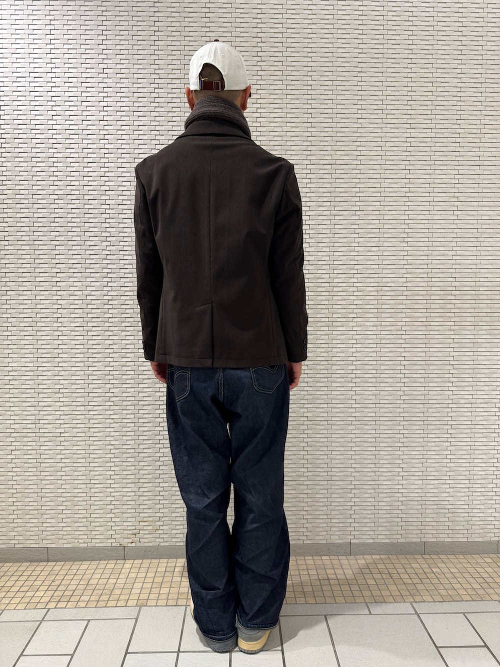 ブラウン系のスーツジャケット、ホワイト系のニット/セーター、ブラウン系のマフラーを着用したメンズの冬コーディネートの3枚目の写真