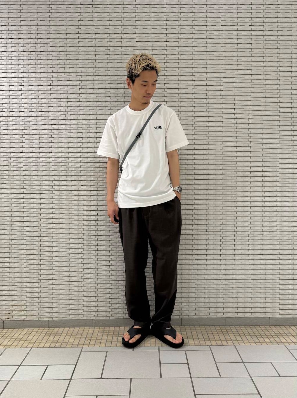 グレー系のショルダーバッグ、ブラウン系のその他パンツ、ホワイト系のTシャツ/カットソーを着用したメンズの夏コーディネートの2枚目の写真