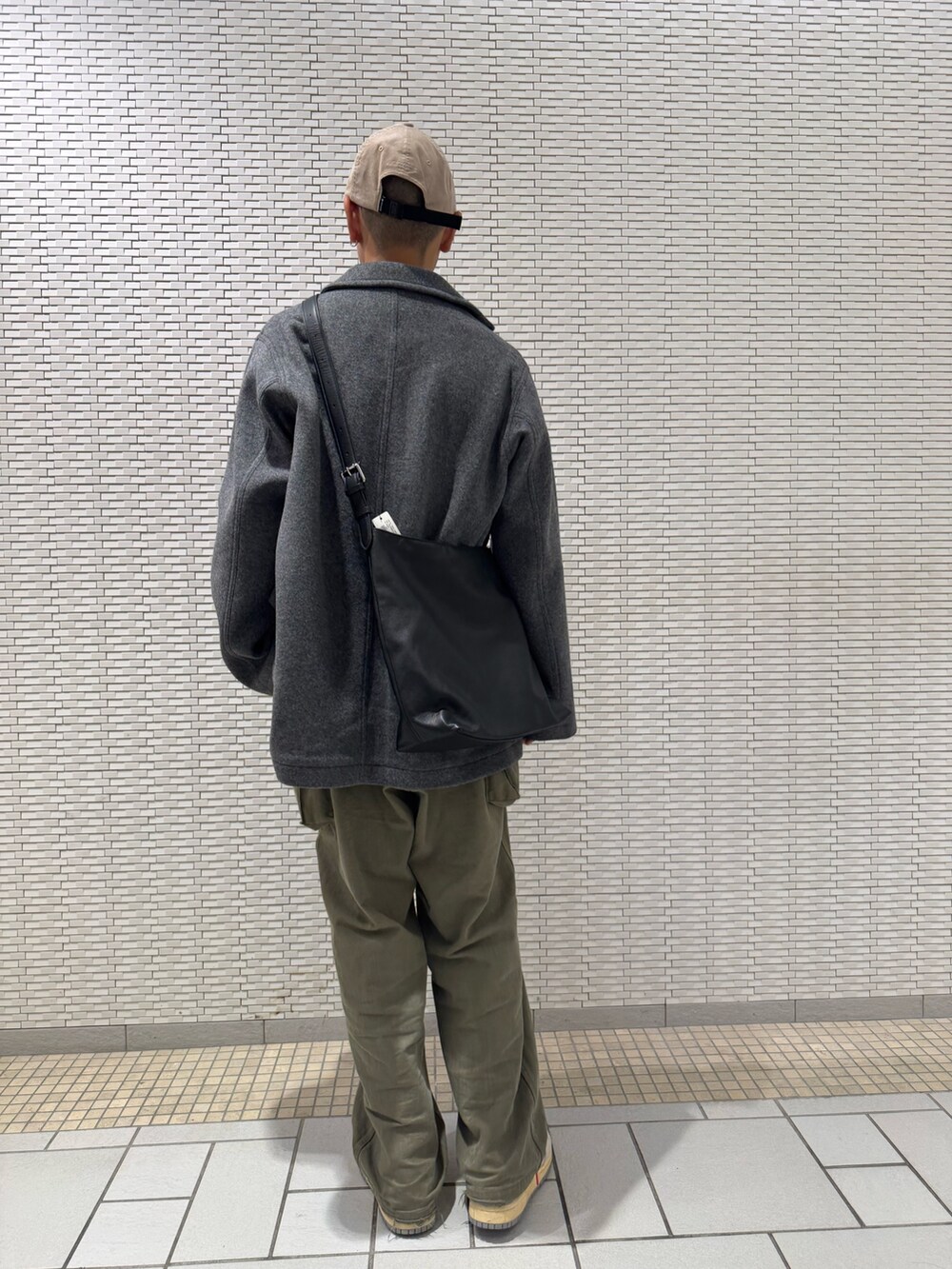 グレー系のテーラードジャケット、ベージュ系のキャップを着用したメンズの秋コーディネートの3枚目の写真