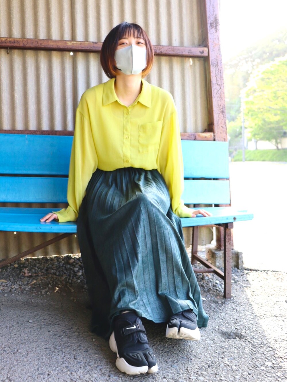 グリーン系のスカート、ブラック系のスニーカー、イエロー系のシャツ/ブラウスを着用したレディースの春コーディネートの2枚目の写真