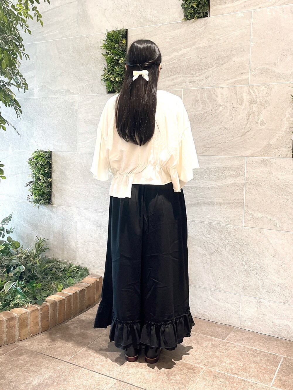 ベージュ系のハンドバッグ、ホワイト系のTシャツ/カットソー、ブラック系のその他パンツを着用したレディースの夏コーディネートの2枚目の写真