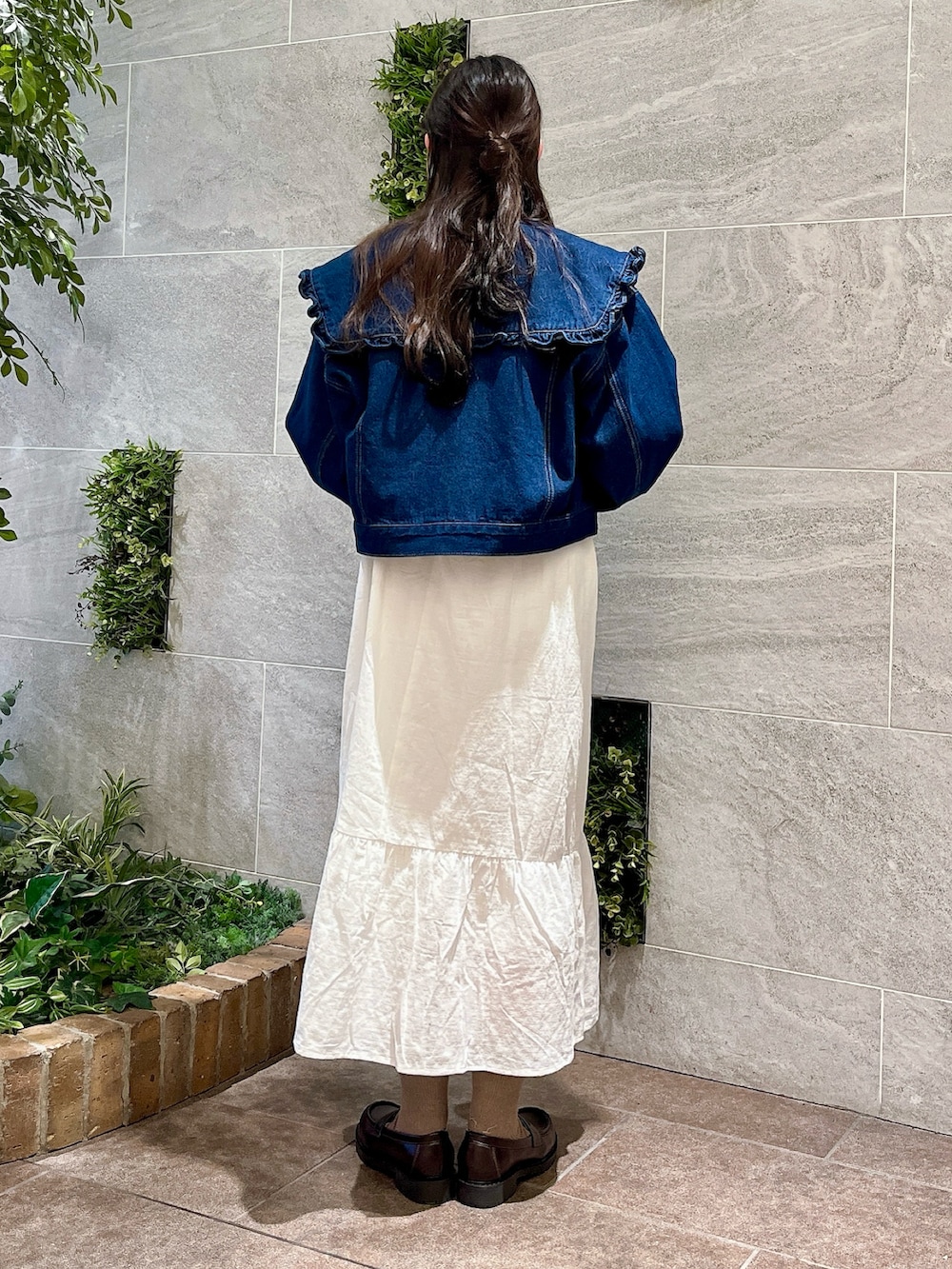 ブラウン系のローファー、ホワイト系のワンピース、ブルー系のTシャツ/カットソーを着用したレディースの冬コーディネートの2枚目の写真