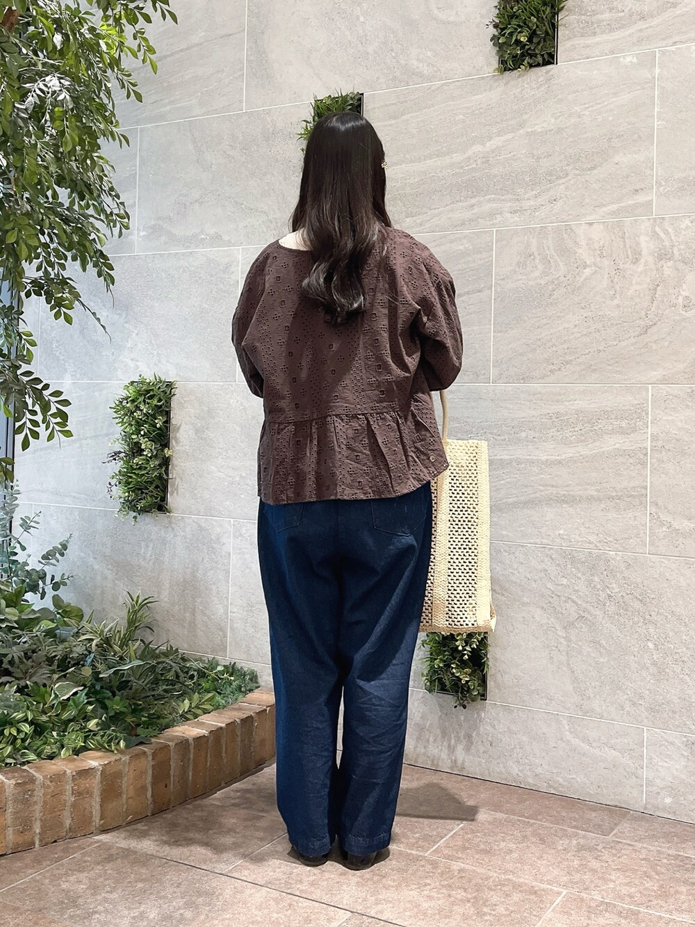 ホワイト系のハンドバッグ、ブラウン系のノーカラージャケット、ホワイト系のタンクトップを着用したレディースの春コーディネートの2枚目の写真