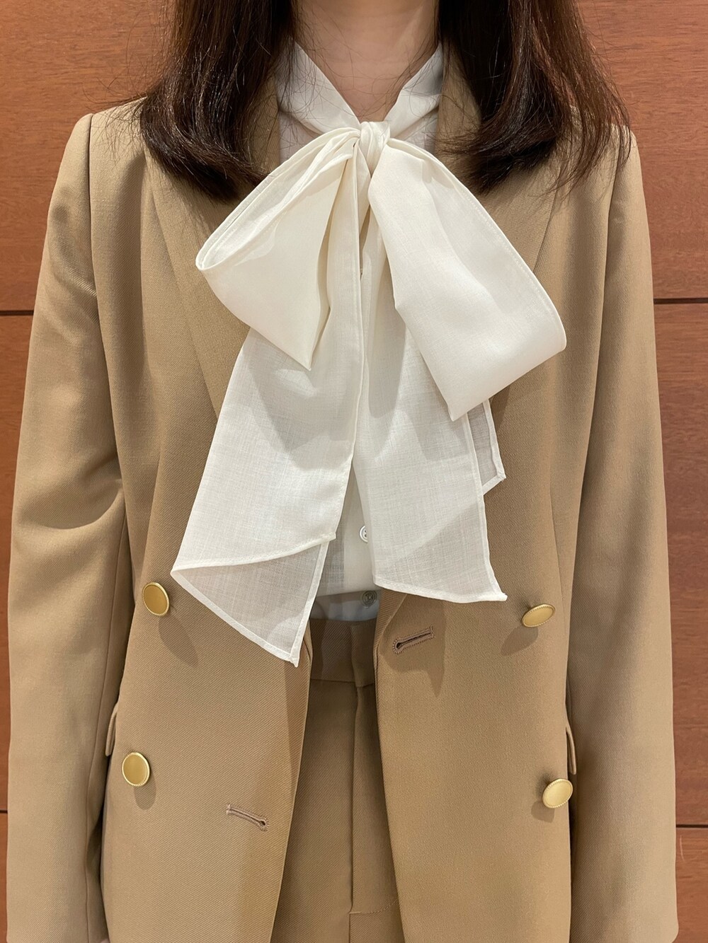 イエロー系のテーラードジャケット、イエロー系のスラックス、ホワイト系のシャツ/ブラウスを着用したレディースの秋コーディネートの9枚目の写真