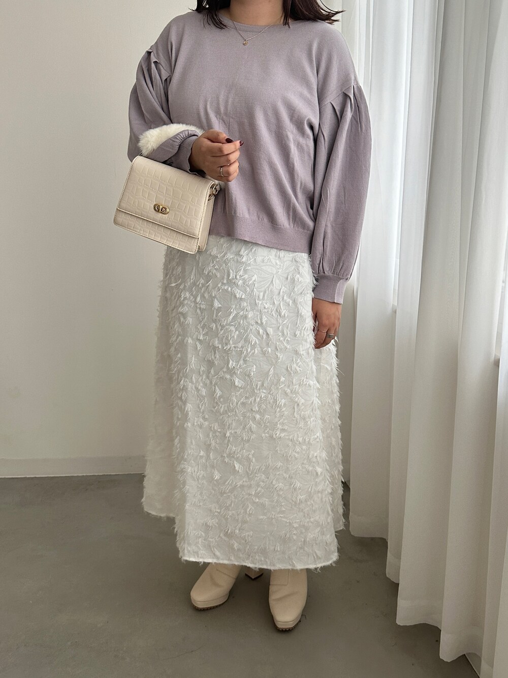 ホワイト系のスカート、パープル系のカーディガン/ボレロを着用したレディースの秋コーディネートの2枚目の写真