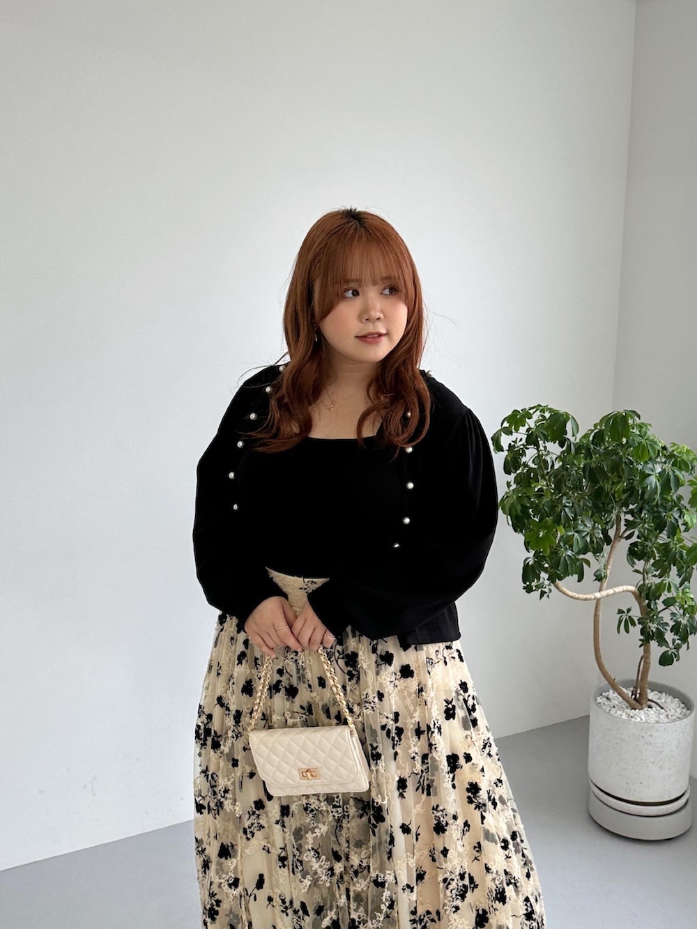 ブラック系のワンピース、ホワイト系のカーディガン/ボレロを着用したレディースの秋コーディネートの2枚目の写真