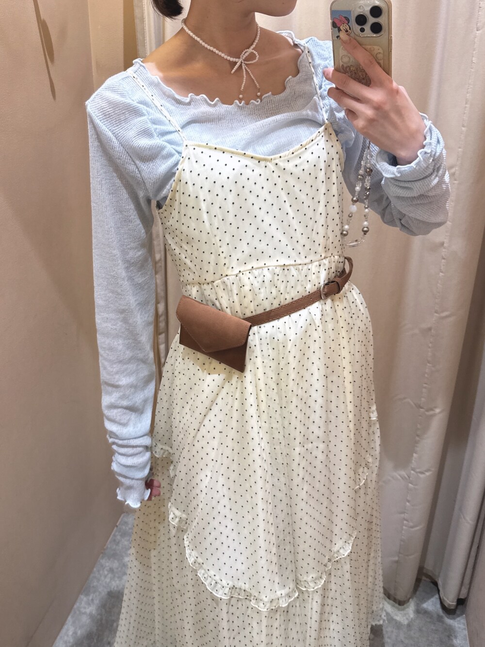 イエロー系のブーツ、ホワイト系のワンピース、ブルー系のTシャツ/カットソーを着用したレディースの春コーディネートの3枚目の写真