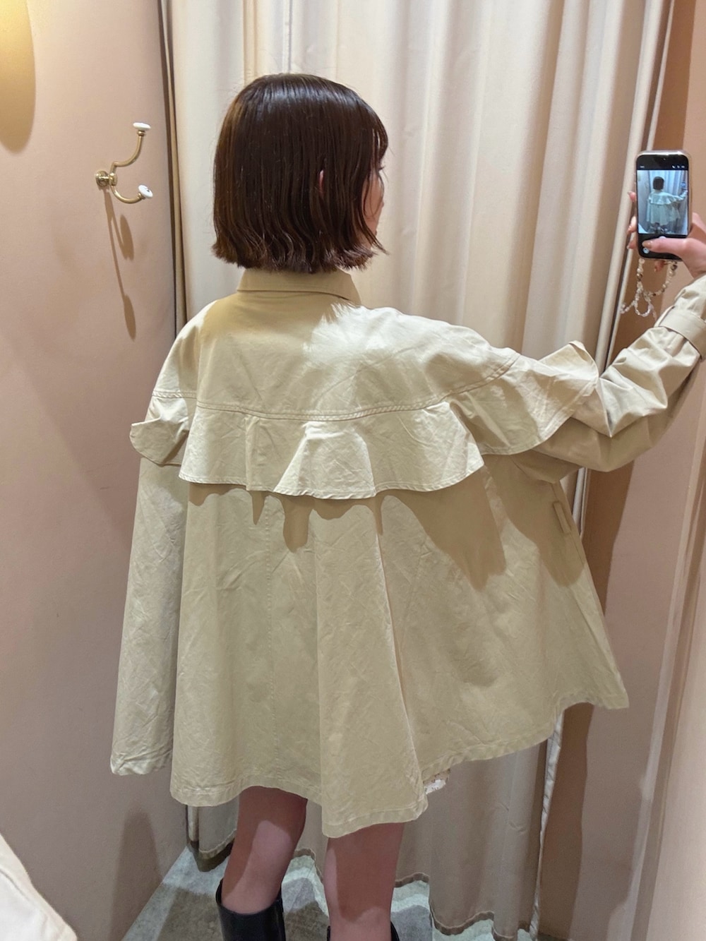 ベージュ系のトレンチコートを着用したレディースの春コーディネートの5枚目の写真