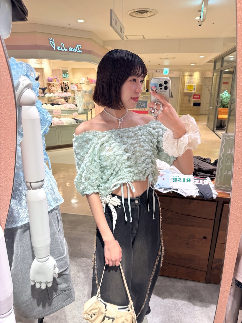 グリーン系のシャツ/ブラウス、ブラック系のデニムパンツ、ホワイト系のトートバッグを着用したレディースの夏コーディネートの3枚目の写真