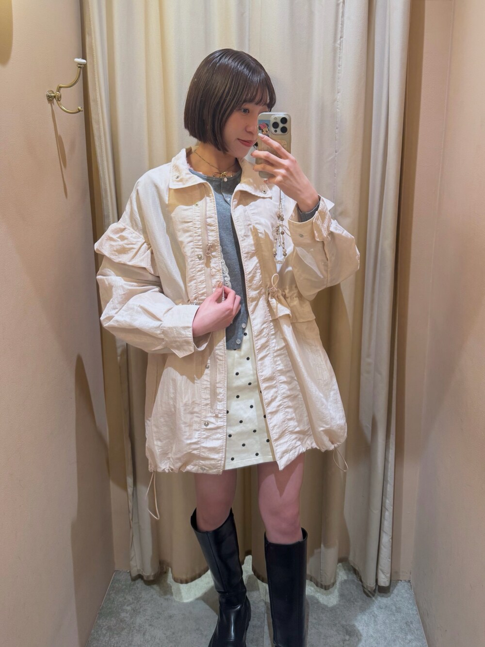 グレー系のカーディガン/ボレロ、ピンク系のブルゾン、ホワイト系のスカートを着用したレディースの冬コーディネートの3枚目の写真