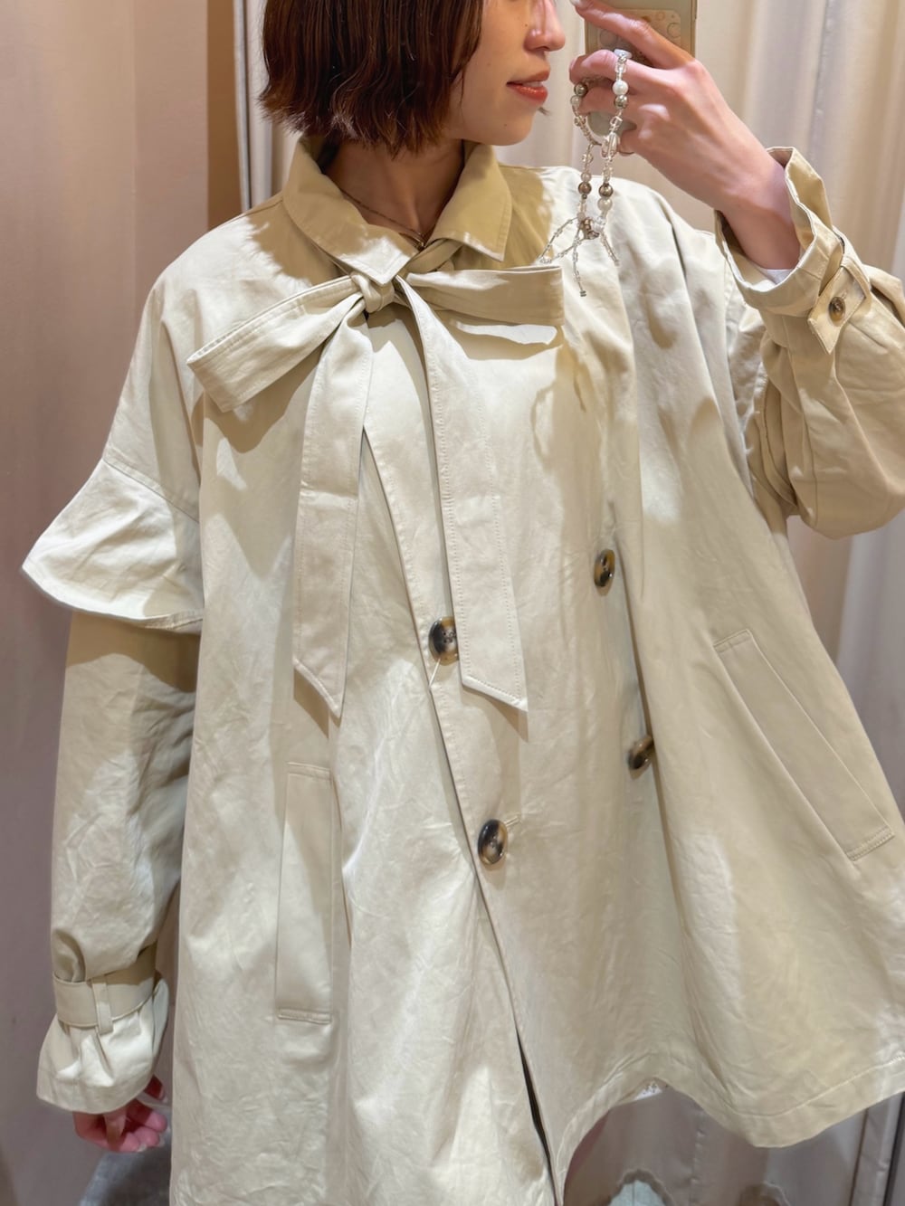 ベージュ系のトレンチコートを着用したレディースの春コーディネートの4枚目の写真