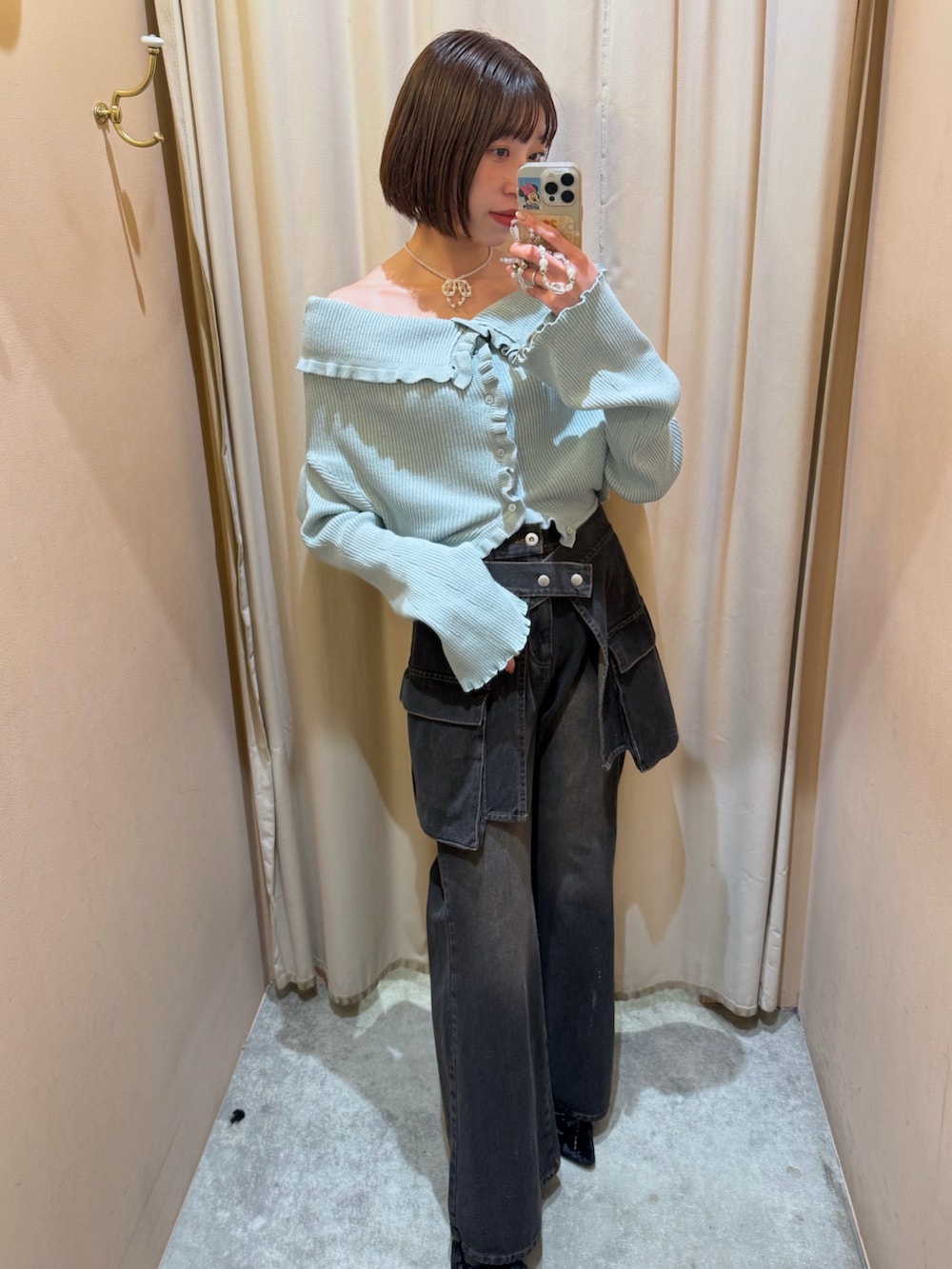 グリーン系のカーディガン/ボレロ、ブラック系のデニムパンツを着用したレディースの冬コーディネートの2枚目の写真