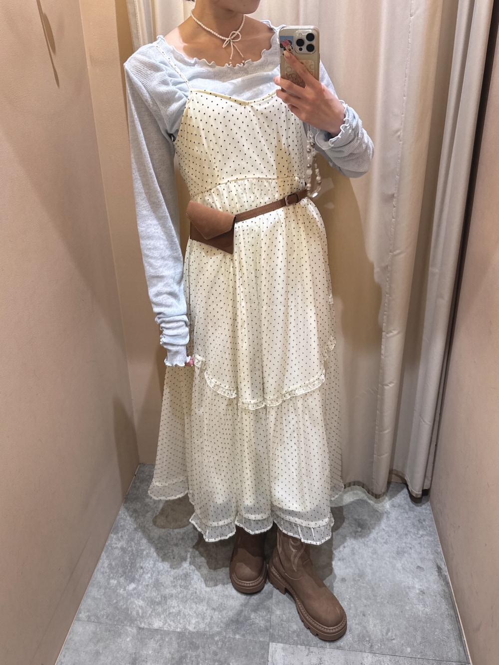 イエロー系のブーツ、ホワイト系のワンピース、ブルー系のTシャツ/カットソーを着用したレディースの春コーディネートの5枚目の写真