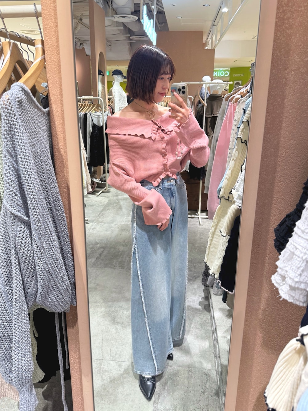 ピンク系のカーディガン/ボレロ、ブルー系のデニムパンツを着用したレディースの春コーディネートの2枚目の写真