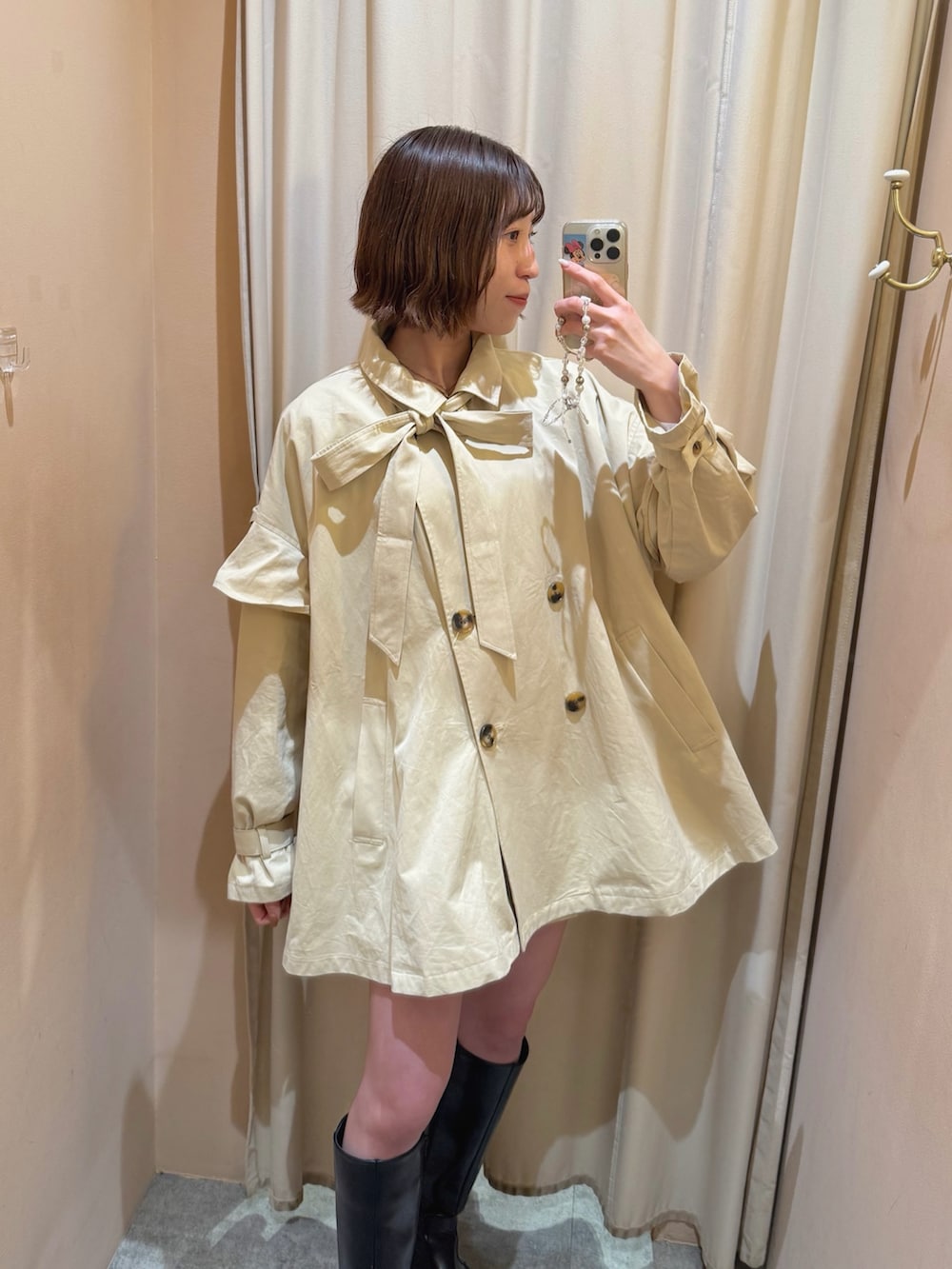 ベージュ系のトレンチコートを着用したレディースの春コーディネートの3枚目の写真