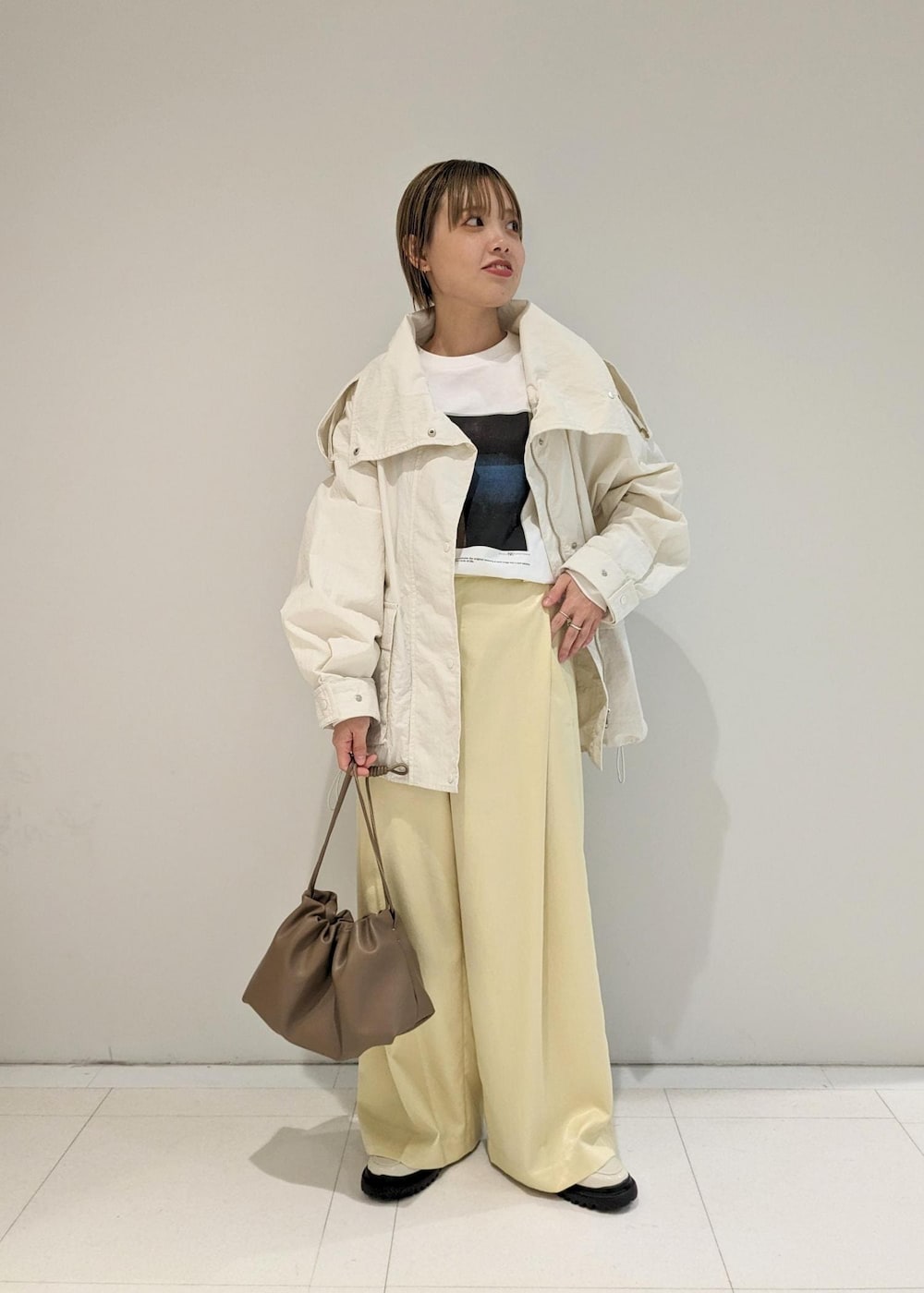 イエロー系のその他パンツ、ホワイト系のローファー、ブラウン系のショルダーバッグを着用したレディースの冬コーディネートの4枚目の写真