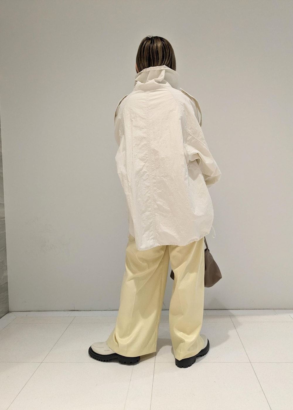 イエロー系のその他パンツ、ホワイト系のローファー、ブラウン系のショルダーバッグを着用したレディースの冬コーディネートの2枚目の写真