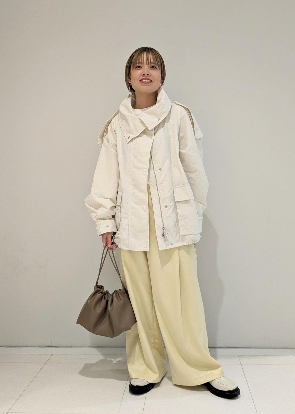 イエロー系のその他パンツ、ホワイト系のローファー、ブラウン系のショルダーバッグを着用したレディースの冬コーディネートの3枚目の写真