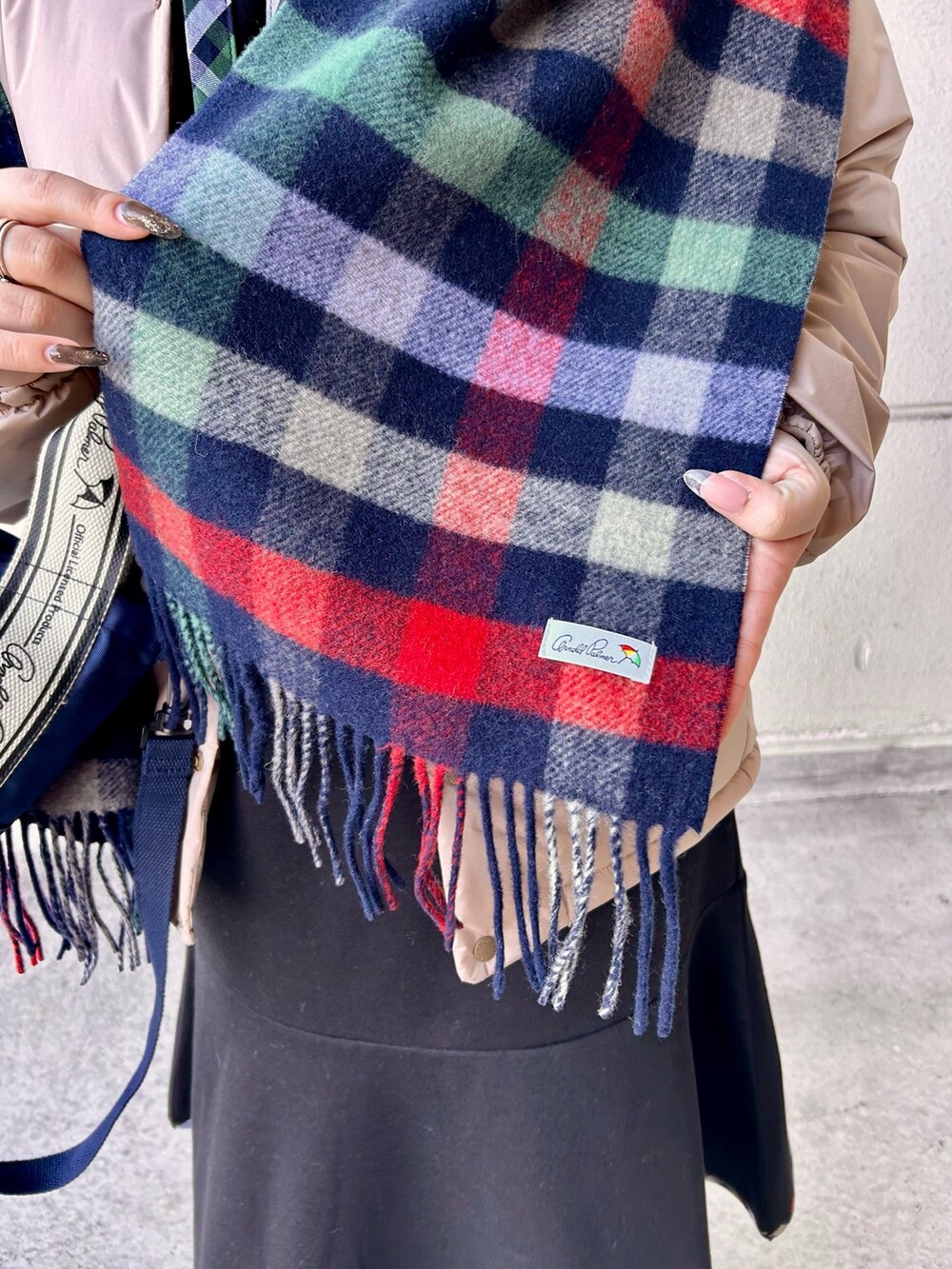 ブラック系のワンピース、ブルー系のトートバッグ、ベージュ系のその他アウターを着用したレディースの冬コーディネートの6枚目の写真