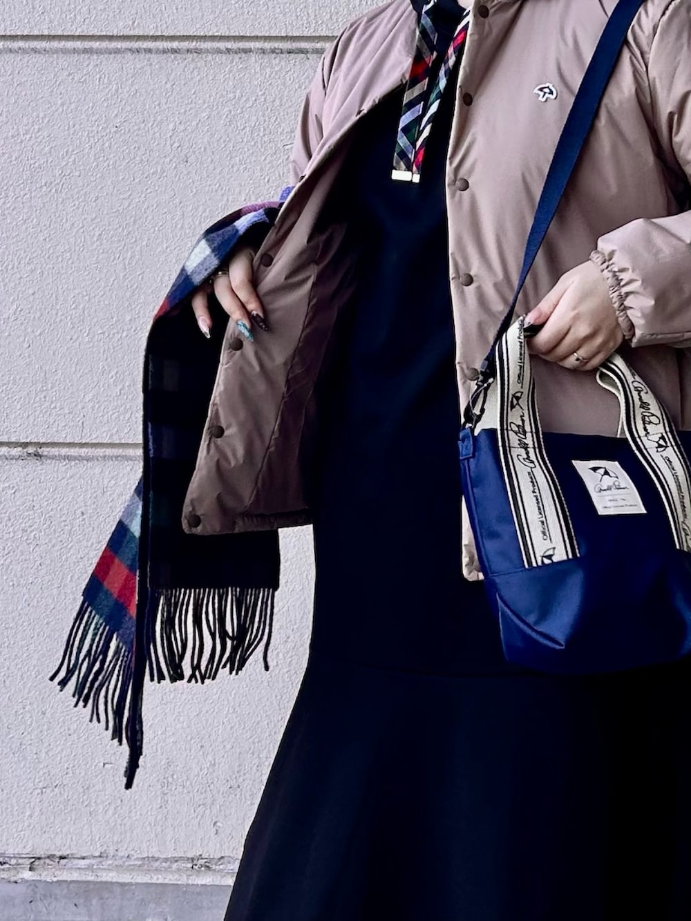 ブラック系のワンピース、ブルー系のトートバッグ、ベージュ系のその他アウターを着用したレディースの冬コーディネートの4枚目の写真