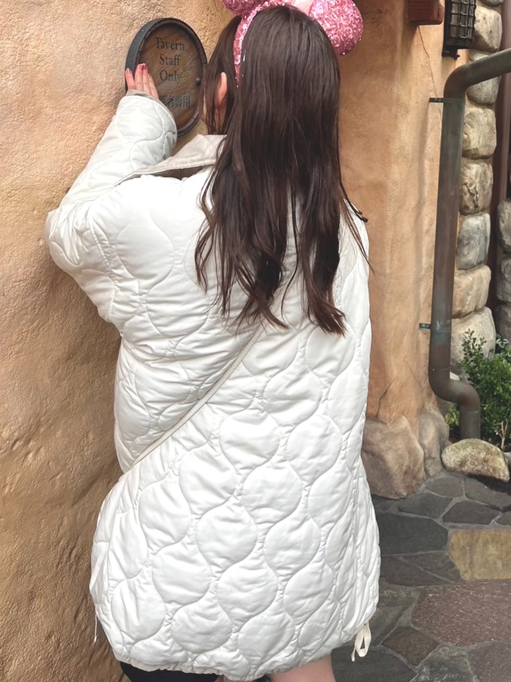 ホワイト系のブルゾン、ピンク系のニット/セーター、ブラック系のブーツを着用したレディースの冬コーディネートの3枚目の写真