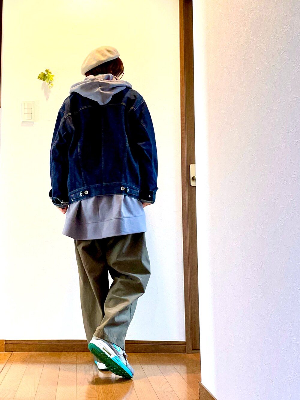 ブルー系のデニムジャケット、グレー系のパーカー、グリーン系のその他パンツを着用したレディースの春コーディネートの3枚目の写真