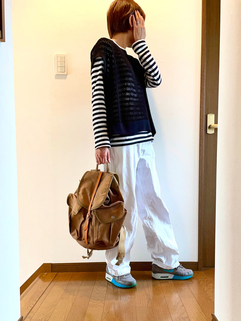 ブラック系のベスト、ホワイト系のTシャツ/カットソー、ホワイト系のパンツを着用したレディースの春コーディネートの2枚目の写真